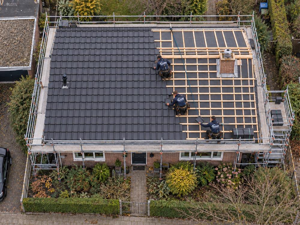 Luchtfoto van een woning waarvan het dak wordt vernieuwd: nieuwe dakpannen naast nieuwe panlatten