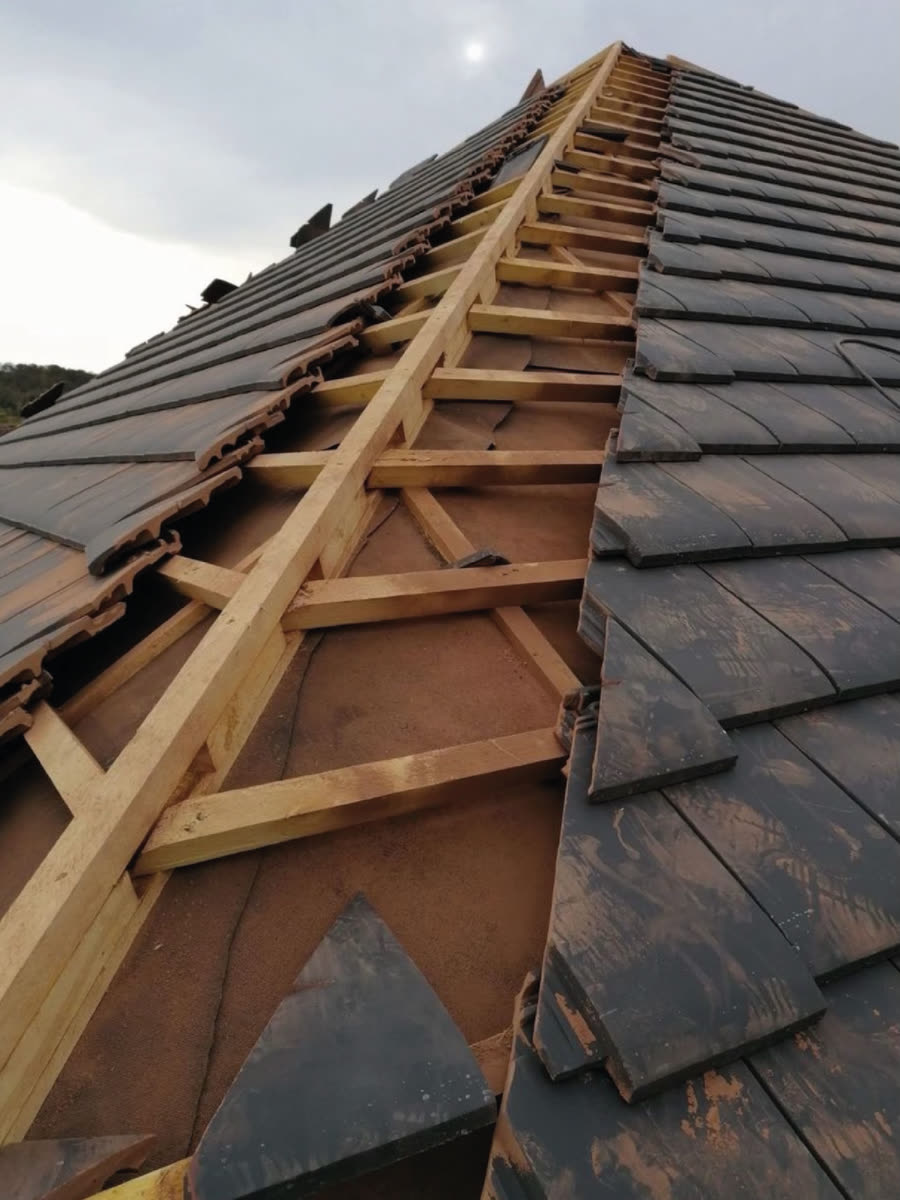 Nieuwe panlatten en dakpannen tijdens de renovatie van een hellend dak