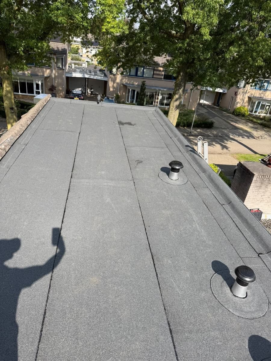 Plat dak met nieuwe bitumen dakbedekking en doorvoeren